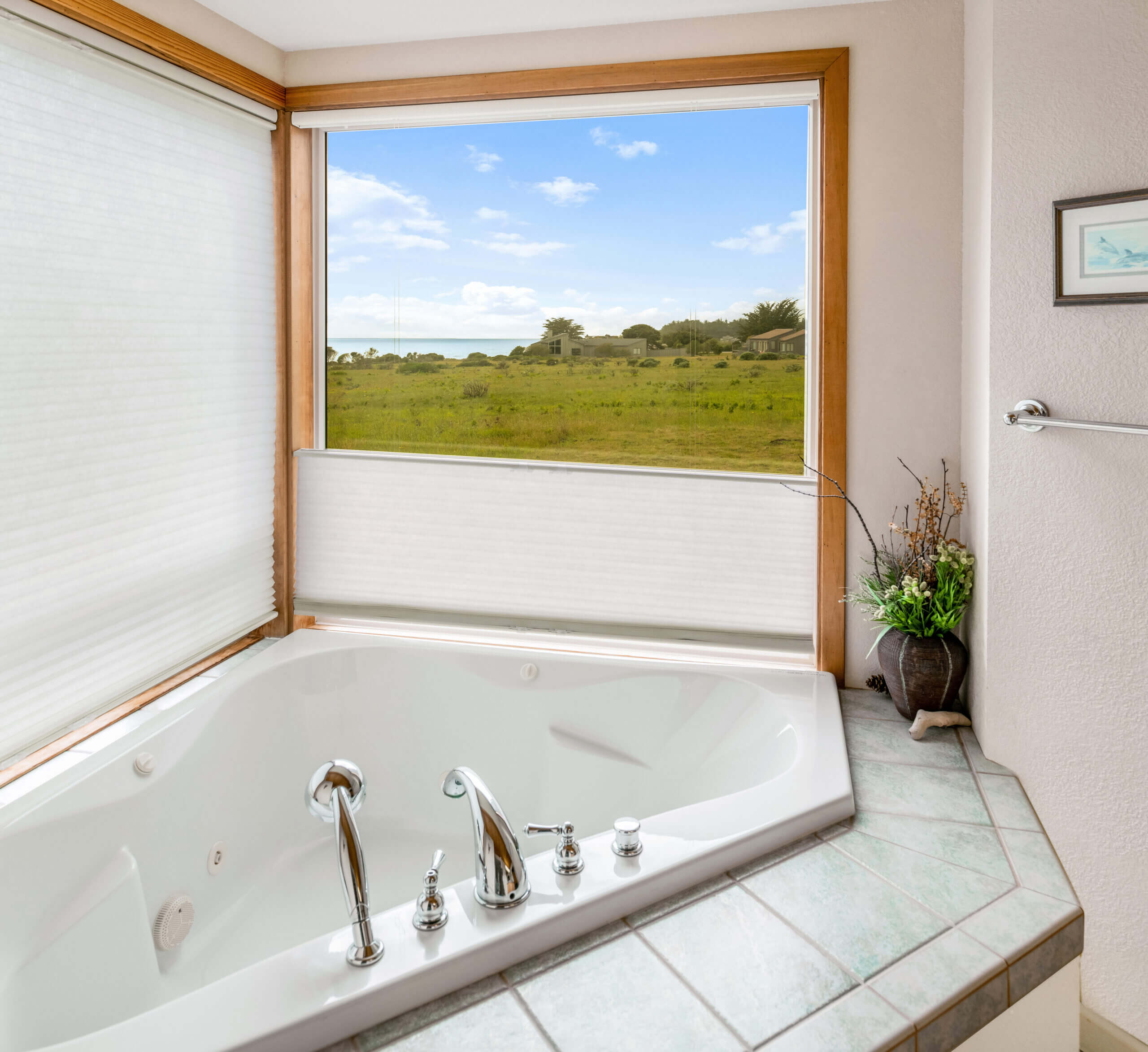 Pelicans Rest upstairs bath with large spa bath window with view of meadow