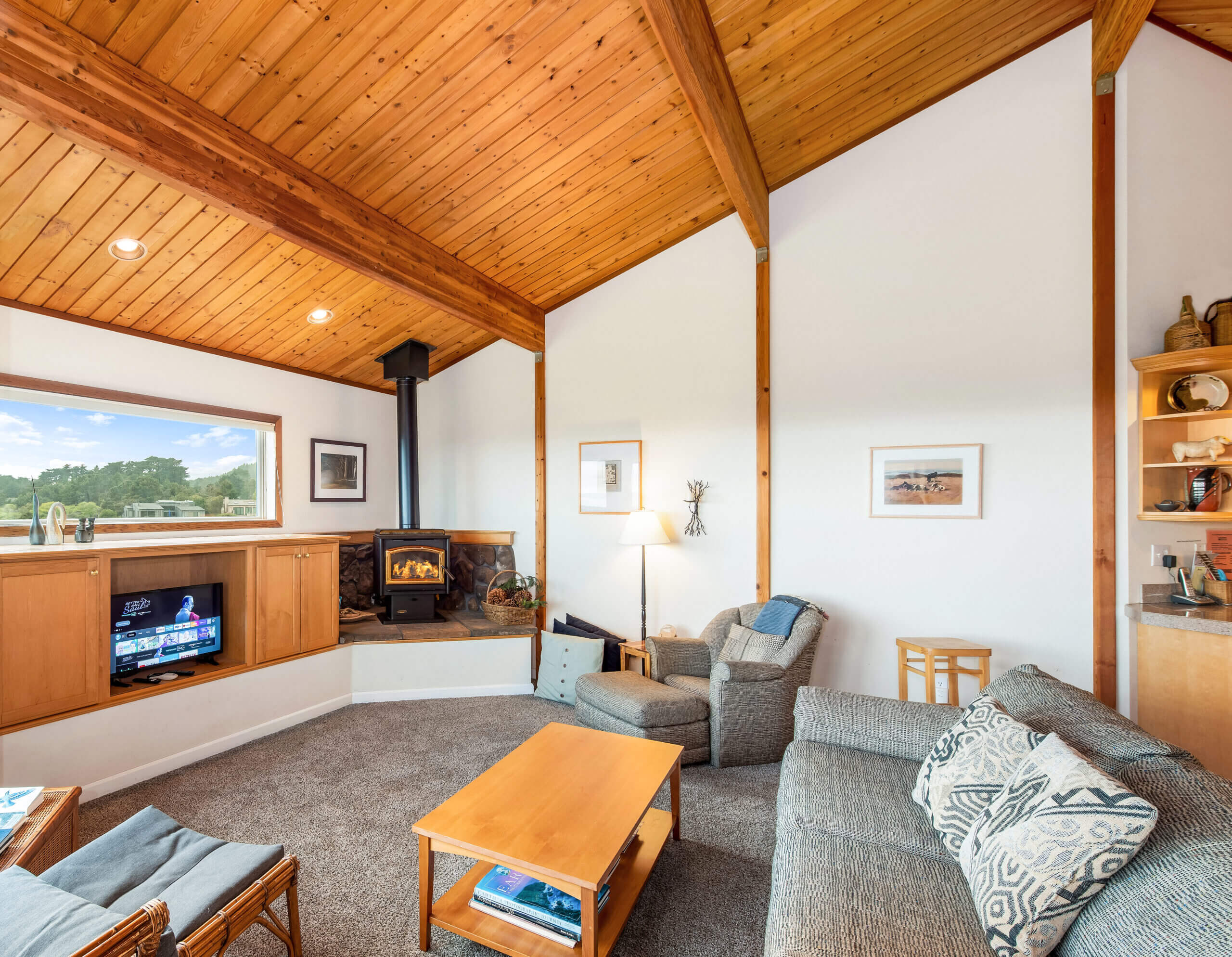 Pelicans Rest upper living area with TV, firestove and wood beam ceilings