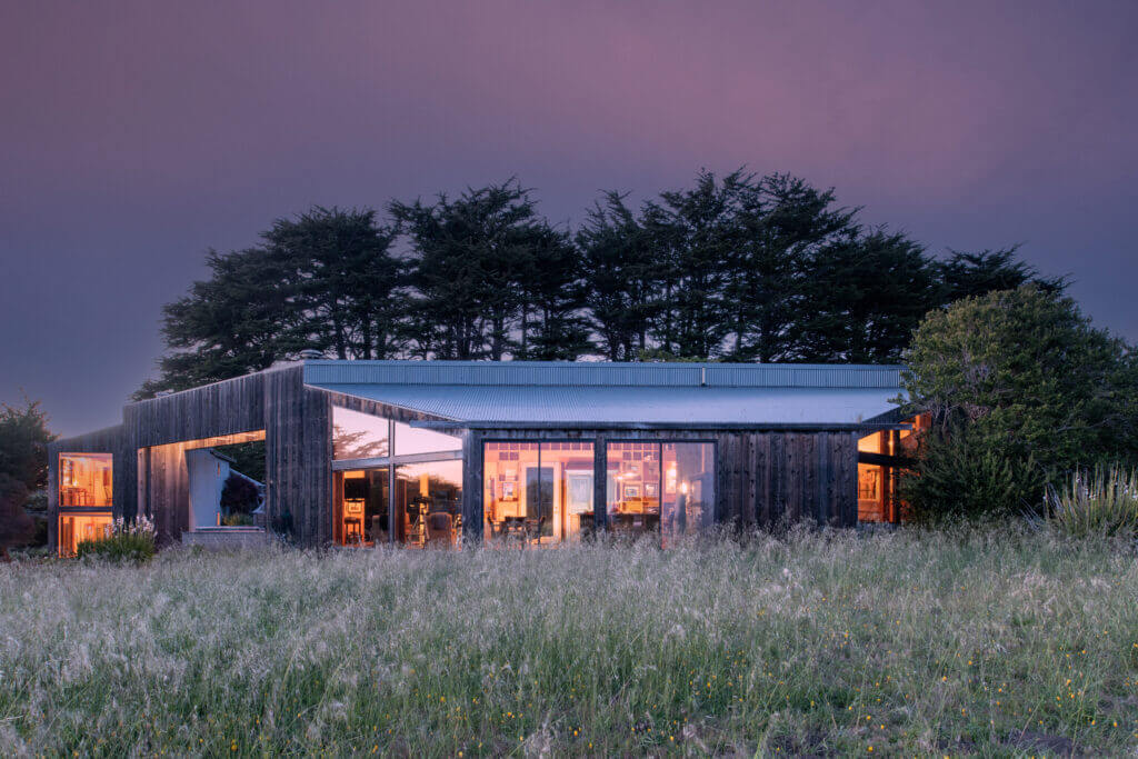 Tin Roof exterior view, back of house, dusk in long grass