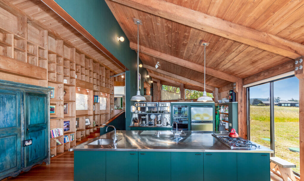 Tin Roof kitchen with large island, blue cabinets, high ceilings