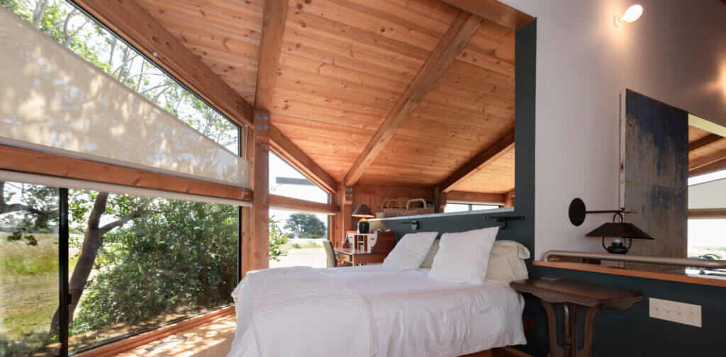 Tin Roof master bedroom with large window high wood ceilings