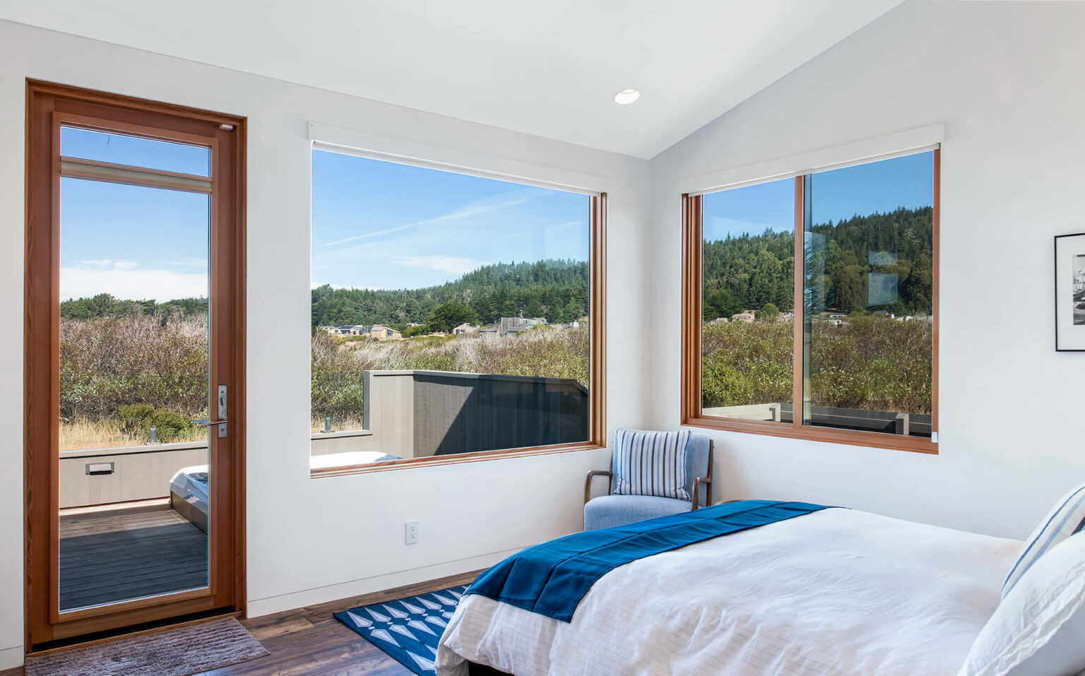 Beach Dreams bright white 1st queen bedroom with view of small deck looking to meadow