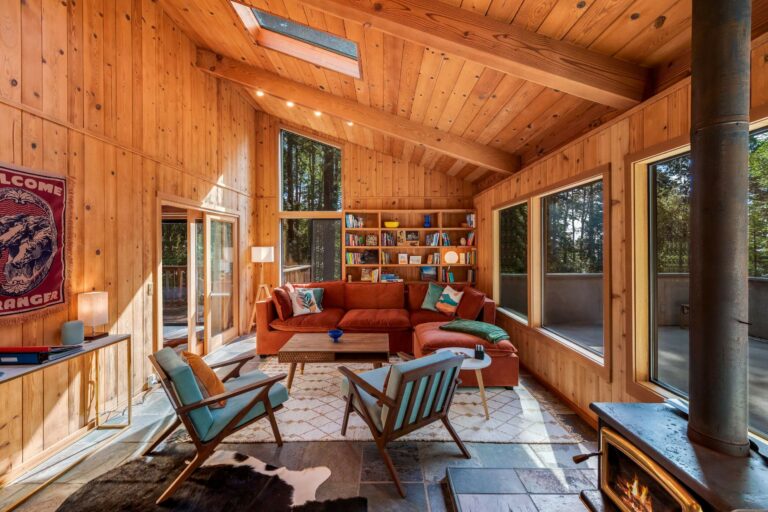 Sea Pony - bright wood paneled living room with sofa and large windows