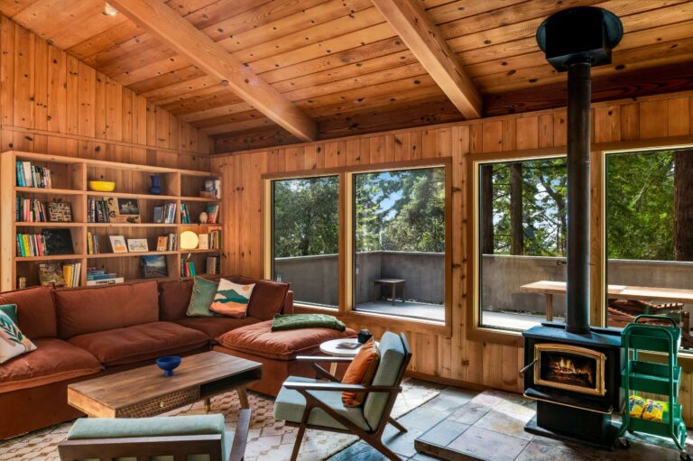 Sea Pony - bright wood paneled living room with sofa, wood stove and large windows