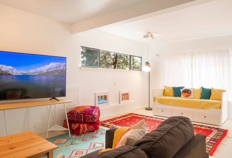 Sea Pony - 1st floor bright TV room with colorful carpet, sofa and pillows