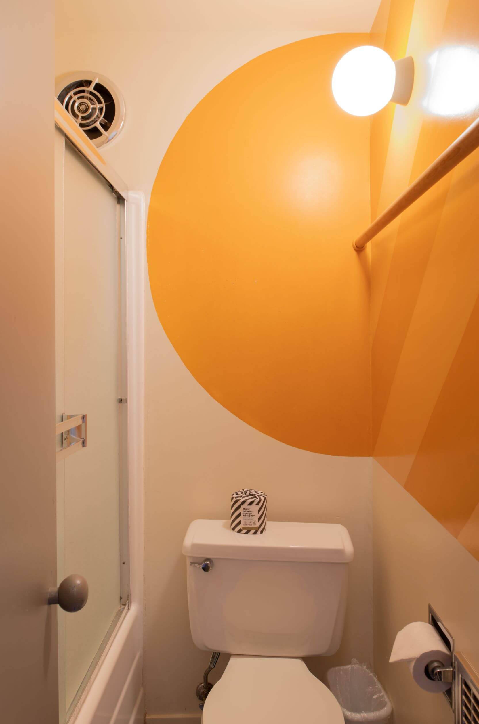 Moore Condo #9 - small bathroom and shower with bright yellow circle painted on wall.