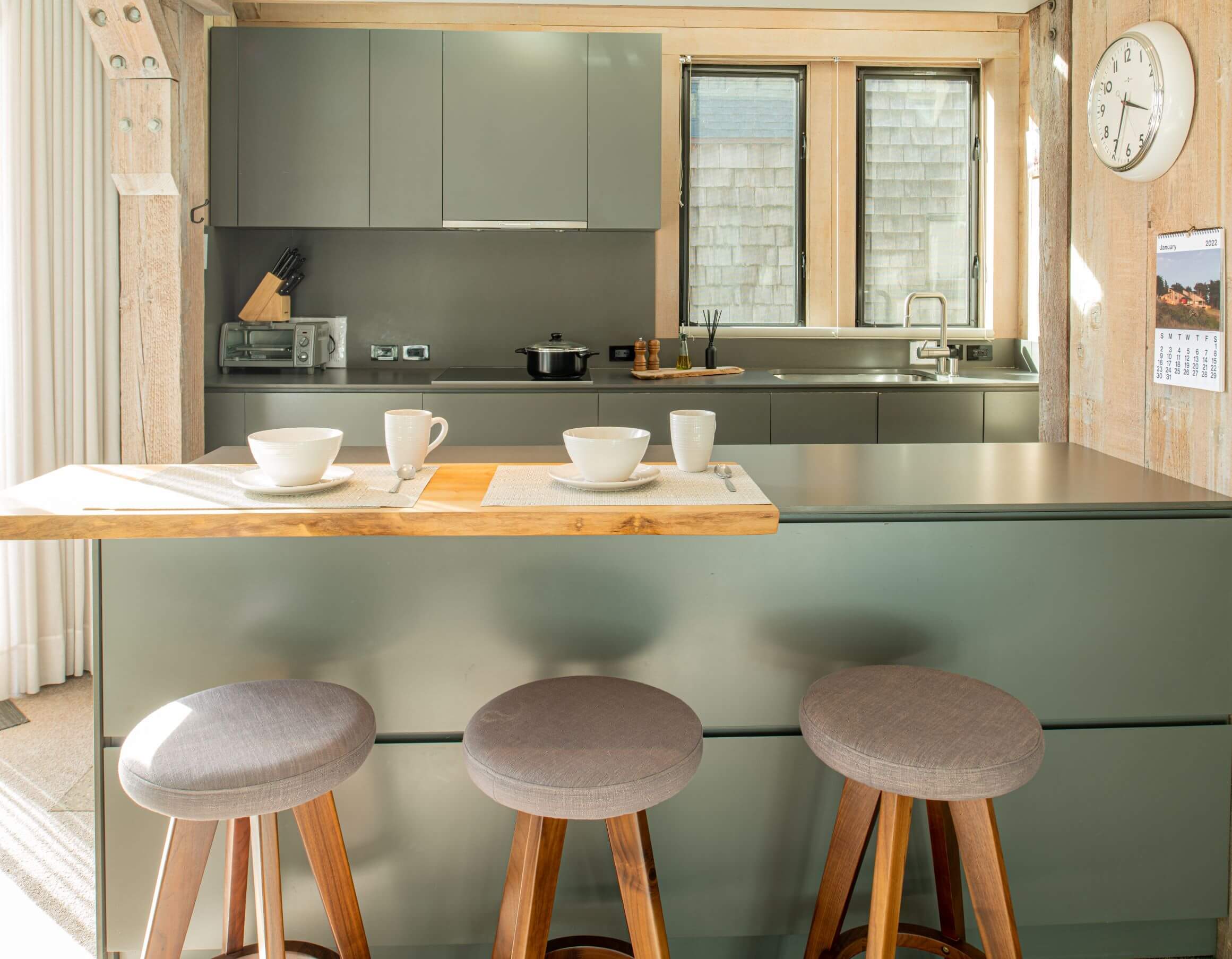 Seaview: bright kitchen breakfast bar with high stools looking into kitchen.